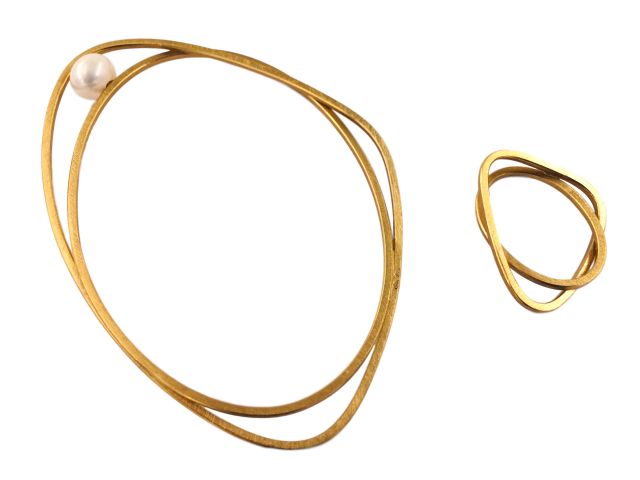 Armreif mit Süßwasserperle und passender Ring, beides aus vergldetem Silber. Die Form besteht aus zwei ineinander verschlungenen Elementen, einem ovalen und einem gerundet-dreieckigen.