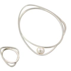 Ring aus Silber und passender Armreif mit Süßwasserperle. Die Form besteht aus zwei ineinander verschlungenen Elementen, einem ovalen und einem gerundet-dreieckigen.