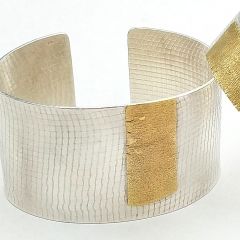 Doppelfärbiger Armreif aus Silber und Gold mit Textur.