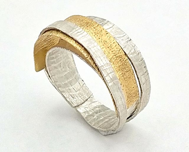 Doppelfärbiger Ring mit Textur  aus der Serie „Simply elegant“. Material Silber und 18 karätiges Gelbgold.