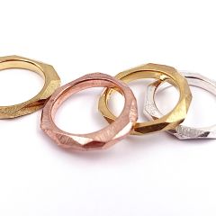 Ringe aus Sterlingsilber sowie in verschiedenen Goldfarben vergoldet, mit schräg angeschliffenen, kristallin wirkenden Flächen.