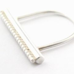 Ring aus Silber mit einem Oberteil in runder, länglicher Form mit einer Zierleiste aus Kugeldraht. 