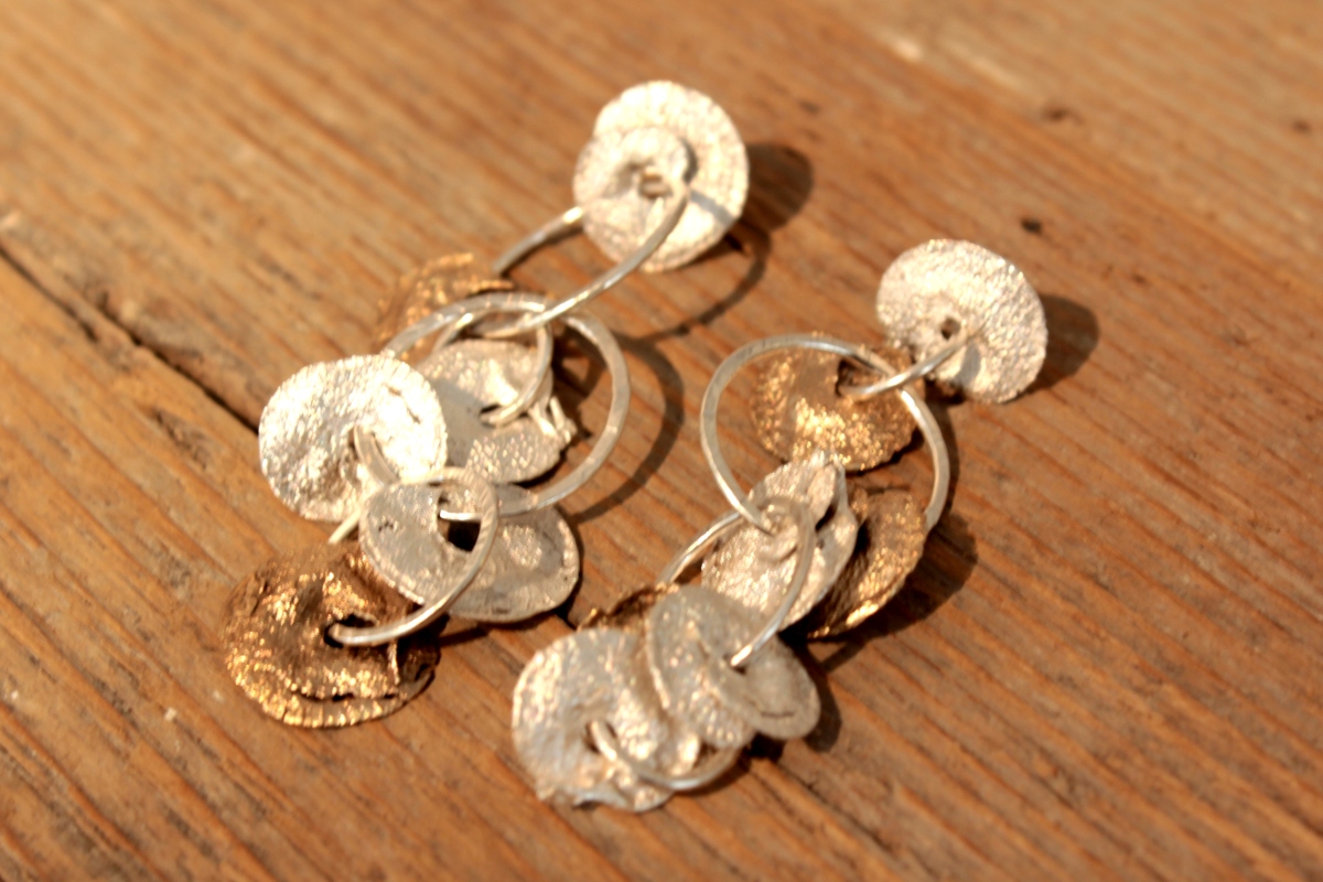 Spanish Seeds-Ohrringe aus Silber und Bronze mit gegossenen, scheibenförmigen Samenhülsen.